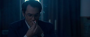 Movie still from “Pawn Sacrifice” (2014), directed by Edward Zwick – A man in a suit smoking a cigarette in front of candles; Close Up shot, Low angle