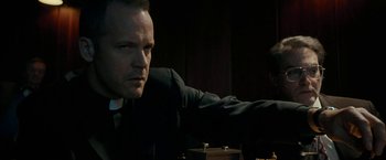 Movie still from “Pawn Sacrifice” (2014), directed by Edward Zwick – A man wearing a suit and tie sitting in front of another man; Close Up shot, Over the shoulder angle