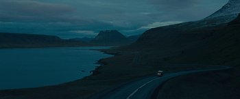 Movie still from “Pawn Sacrifice” (2014), directed by Edward Zwick – A car driving down a road next to a body of water at night; Extreme Wide shot, High angle