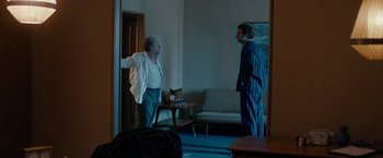 Movie still from “Pawn Sacrifice” (2014), directed by Edward Zwick – Two men standing in a living room talking to each other; Wide shot, Over the shoulder angle