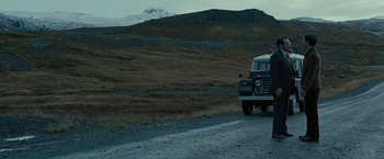 Movie still from “Pawn Sacrifice” (2014), directed by Edward Zwick – A truck driving down a dirt road near a mountain; Extreme Wide shot, Low angle