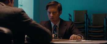 Movie still from “Pawn Sacrifice” (2014), directed by Edward Zwick – A man sitting at a table in front of a laptop computer; Close Up shot, Low angle