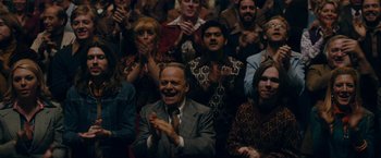 Movie still from “Pawn Sacrifice” (2014), directed by Edward Zwick – A group of people sitting and clapping in front of a crowd; Medium shot, Over the shoulder angle
