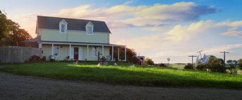 Movie still from “Pearl” (2022), directed by Ti West – A yellow house sitting on top of a lush green field; Extreme Wide shot, Low angle
