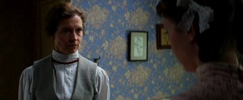 Movie still from “Pearl” (2022), directed by Ti West – A man standing in front of a wall with a picture on the wall; Close Up shot, Over the shoulder angle