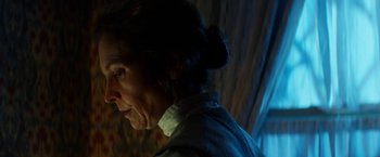 Movie still from “Pearl” (2022), directed by Ti West – An older woman is looking at something in the dark; Close Up shot, Over the shoulder angle