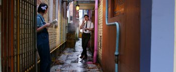 Movie still from “Pearl” (2022), directed by Ti West – A man standing in an alleyway holding a cell phone; Wide shot, High angle