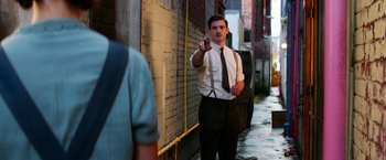 Movie still from “Pearl” (2022), directed by Ti West – A man in a suit and tie pointing at the camera; Medium shot, Over the shoulder angle