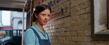 Movie still from “Pearl” (2022), directed by Ti West – A young girl standing in front of a brick wall; Close Up shot, Low angle