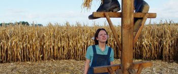 Movie still from “Pearl” (2022), directed by Ti West – A woman standing in front of a corn field; Wide shot, Low angle