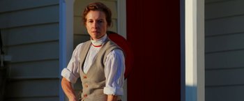 Movie still from “Pearl” (2022), directed by Ti West – A woman standing in front of a red door; Medium shot, Low angle