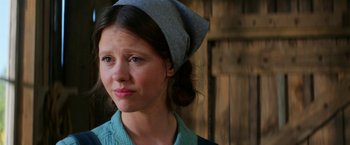 Movie still from “Pearl” (2022), directed by Ti West – A woman wearing a head scarf and looking at the camera; Close Up shot, Over the shoulder angle