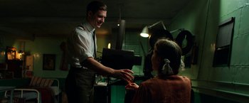 Movie still from “Pearl” (2022), directed by Ti West – A man and a woman are shaking hands in front of a camera; Medium shot, Over the shoulder angle