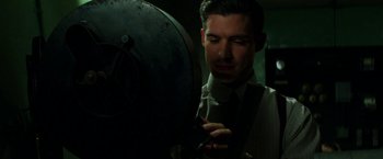 Movie still from “Pearl” (2022), directed by Ti West – A man wearing a suit and tie looking at a mirror; Close Up shot, Low angle