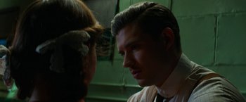 Movie still from “Pearl” (2022), directed by Ti West – A man and a woman face to face in front of a green wall; Close Up shot, Low angle