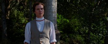 Movie still from “Pearl” (2022), directed by Ti West – A person standing in front of a tree; Medium shot, Low angle