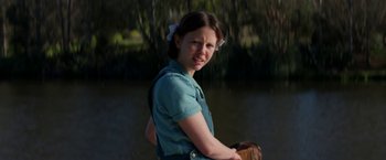 Movie still from “Pearl” (2022), directed by Ti West – A young woman standing next to a body of water; Medium shot, Over the shoulder angle