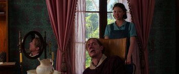 Movie still from “Pearl” (2022), directed by Ti West – An older man and a young woman looking out a window; Medium shot, Low angle