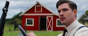 Movie still from “Pearl” (2022), directed by Ti West – A man standing in front of a red barn; Close Up shot, Over the shoulder angle