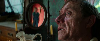 Movie still from “Pearl” (2022), directed by Ti West – An older man looking at himself in the mirror; Close Up shot, Over the shoulder angle