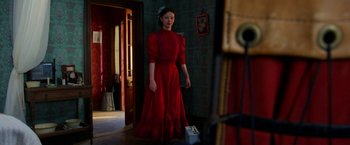 Movie still from “Pearl” (2022), directed by Ti West – A woman in a red dress standing next to a door; Medium shot, Low angle