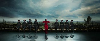 Movie still from “Pearl” (2022), directed by Ti West – A group of men in military uniforms standing next to a woman in red; Wide shot, Low angle
