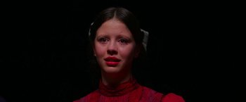 Movie still from “Pearl” (2022), directed by Ti West – A young girl in a red dress is crying in the dark; Close Up shot, Low angle