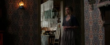 Movie still from “Pearl” (2022), directed by Ti West – A woman standing in front of a kitchen door; Medium shot, Over the shoulder angle