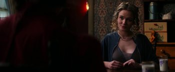 Movie still from “Pearl” (2022), directed by Ti West – A woman standing in front of a wall with a candle; Medium shot, Over the shoulder angle