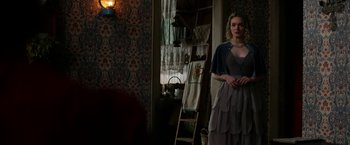 Movie still from “Pearl” (2022), directed by Ti West – A woman standing in front of a mirror in a room; Medium shot, Over the shoulder angle