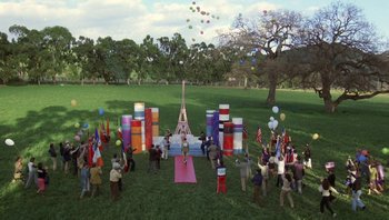 Movie still from “Pee-wee's Big Adventure” (1985), directed by Tim Burton – A group of people standing in the grass near balloons; Extreme Wide shot, High angle