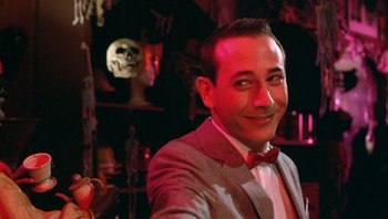 Movie still from “Pee-wee's Big Adventure” (1985), directed by Tim Burton – A man in a suit and bow tie smiling for the camera; Close Up shot, Low angle