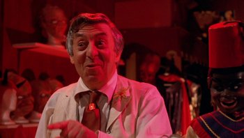 Movie still from “Pee-wee's Big Adventure” (1985), directed by Tim Burton – An older man wearing a white shirt and a red tie; Close Up shot, Over the shoulder angle