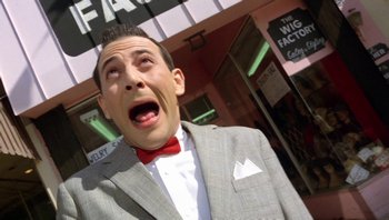 Movie still from “Pee-wee's Big Adventure” (1985), directed by Tim Burton – A man in a gray suit and red bow tie; Close Up shot, Low angle