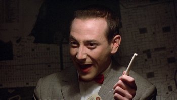 Movie still from “Pee-wee's Big Adventure” (1985), directed by Tim Burton – A man in a suit holding an umbrella; Close Up shot, Over the shoulder angle