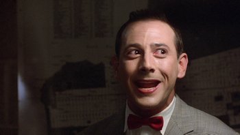 Movie still from “Pee-wee's Big Adventure” (1985), directed by Tim Burton – A person wearing a suit and a red bow tie; Close Up shot, Low angle