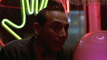 Movie still from “Pee-wee's Big Adventure” (1985), directed by Tim Burton – A person wearing a suit and tie; Close Up shot, Over the shoulder angle