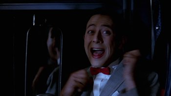Movie still from “Pee-wee's Big Adventure” (1985), directed by Tim Burton – A man in a suit and red bow tie; Close Up shot, Low angle