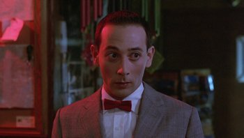 Movie still from “Pee-wee's Big Adventure” (1985), directed by Tim Burton – A person wearing a suit and a red bow tie; Close Up shot, Low angle