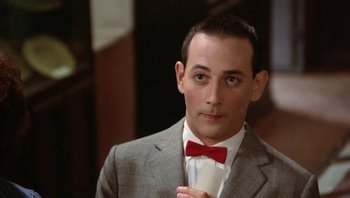 Movie still from “Pee-wee's Big Adventure” (1985), directed by Tim Burton – A man in a suit and a red bow tie; Close Up shot, High angle