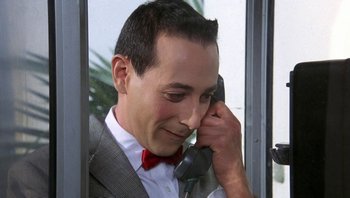 Movie still from “Pee-wee's Big Adventure” (1985), directed by Tim Burton – A person talking on a cell phone; Close Up shot, Low angle