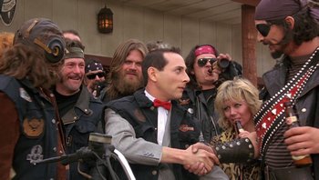 Movie still from “Pee-wee's Big Adventure” (1985), directed by Tim Burton – A group of men and women standing next to each other; Medium shot, Over the shoulder angle