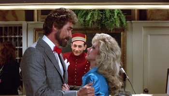 Movie still from “Pee-wee's Big Adventure” (1985), directed by Tim Burton – A man and a woman in front of a man in a uniform; Medium shot, Over the shoulder angle