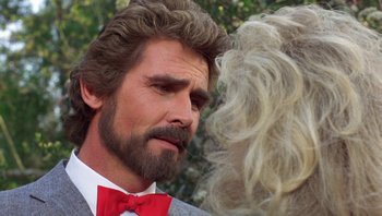 Movie still from “Pee-wee's Big Adventure” (1985), directed by Tim Burton – A man with long hair and a beard talking to a woman with blonde hair; Close Up shot, Over the shoulder angle