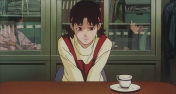 Movie still from “Perfect Blue” (1997), directed by Kô Matsuo – A woman sitting at a table in front of a window; Close Up shot, High angle
