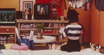Movie still from “Perfect Blue” (1997), directed by Kô Matsuo – A woman sitting in front of a television; Wide shot, High angle