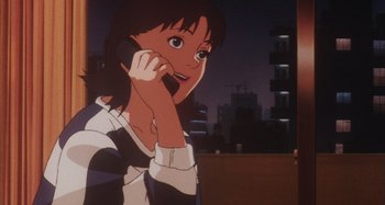 Movie still from “Perfect Blue” (1997), directed by Kô Matsuo – A woman talking on a cell phone while standing in front of a building; Close Up shot, Low angle
