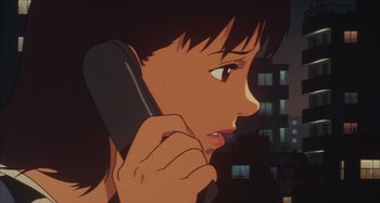 Movie still from “Perfect Blue” (1997), directed by Kô Matsuo – A woman talking on a phone while standing in front of a building; Close Up shot, Low angle