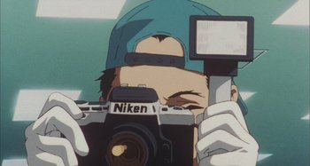 Movie still from “Perfect Blue” (1997), directed by Kô Matsuo – A person taking a picture with a camera; Extreme Close Up shot, Low angle