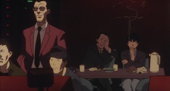 Movie still from “Perfect Blue” (1997), directed by Kô Matsuo – A group of men sitting at a table in a room; Medium shot, Low angle